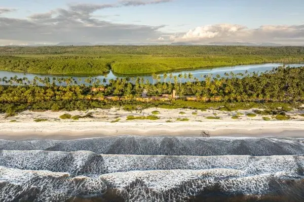 Vista aérea de praia extensa com mata atlântica e rio na região de Una